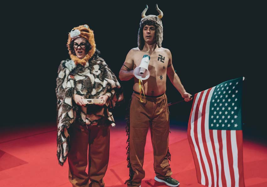 A woman and a man in costume in the middle of a stage performing